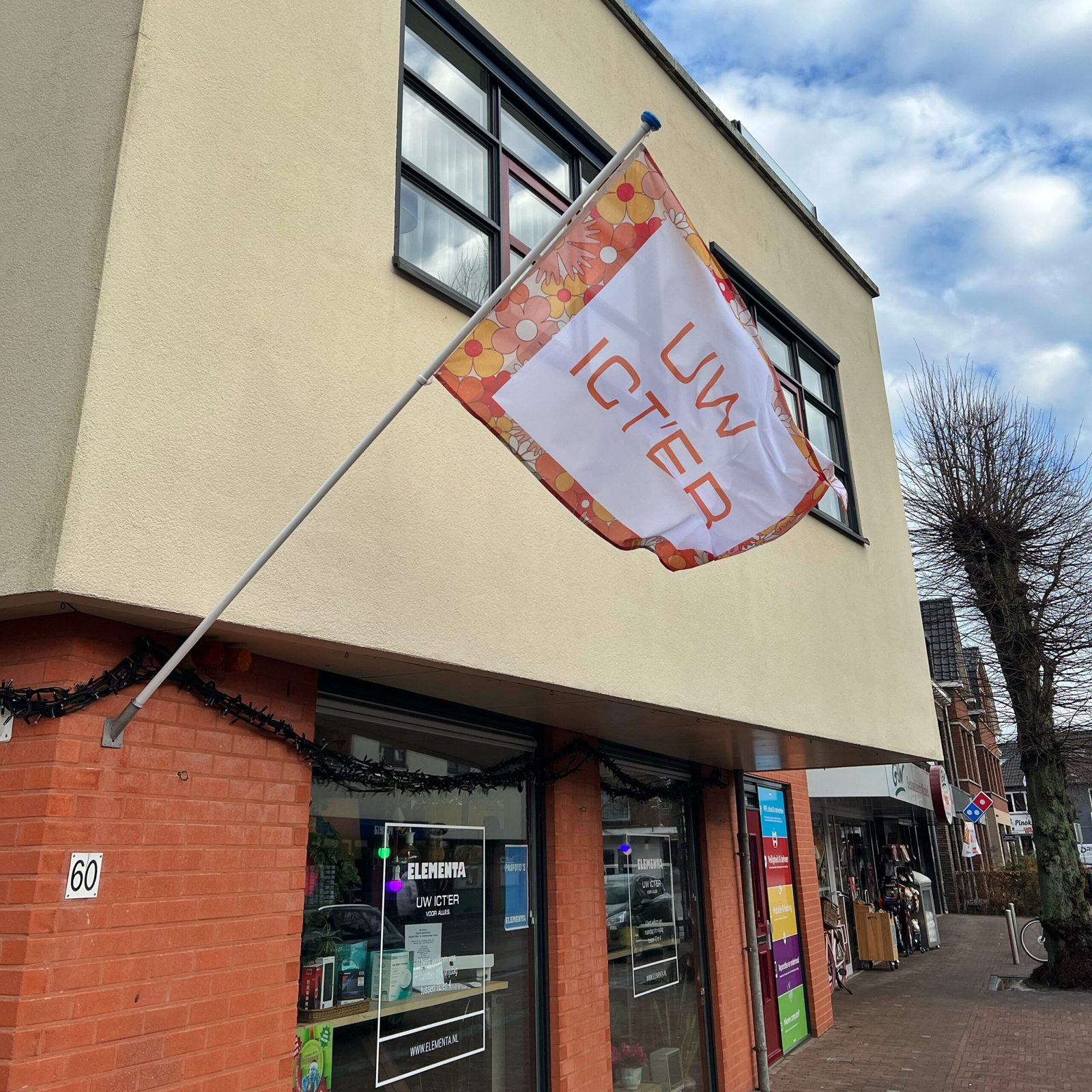 De vlag van ELEMENTA aan de gevel in de Stationsstraat in Ermelo